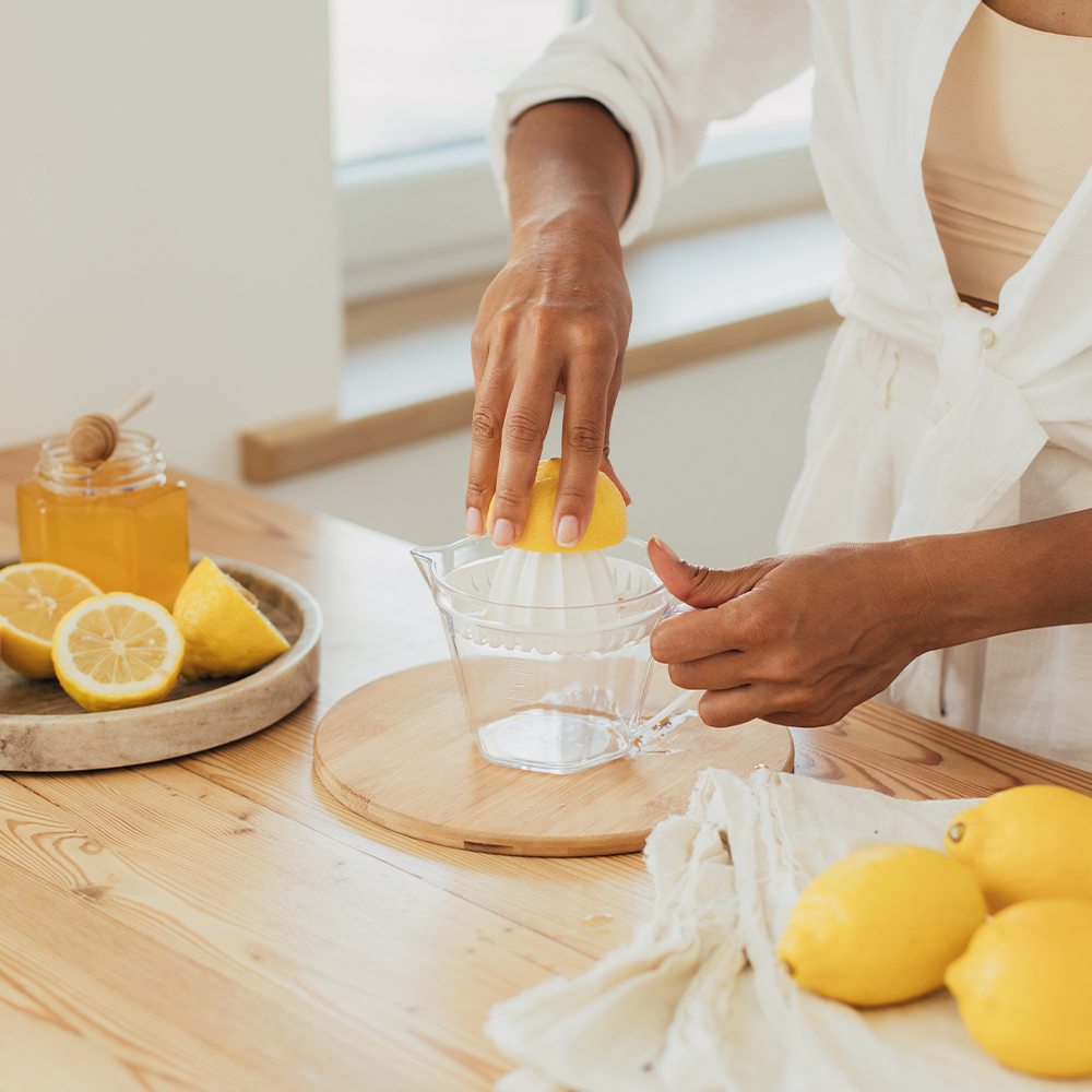Main d'une femme qui presse un ciron dans une cuisine