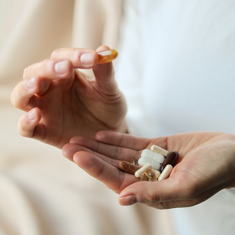 Mains qui trient plusieurs gélules de compléments alimentaires