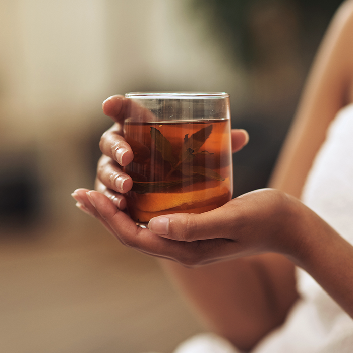 Femme tenant un verre avec des feuilles