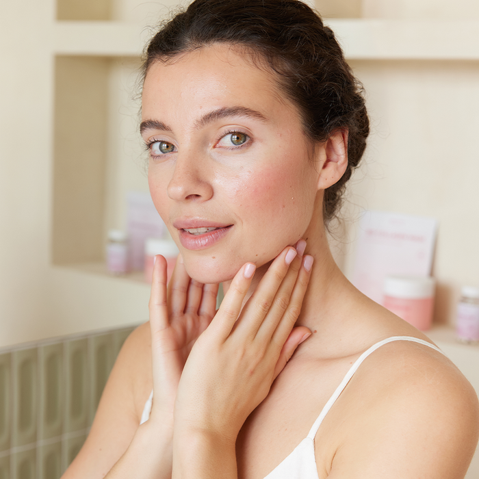 Femme qui pose ses doigt délicatement sur la peau de son visage