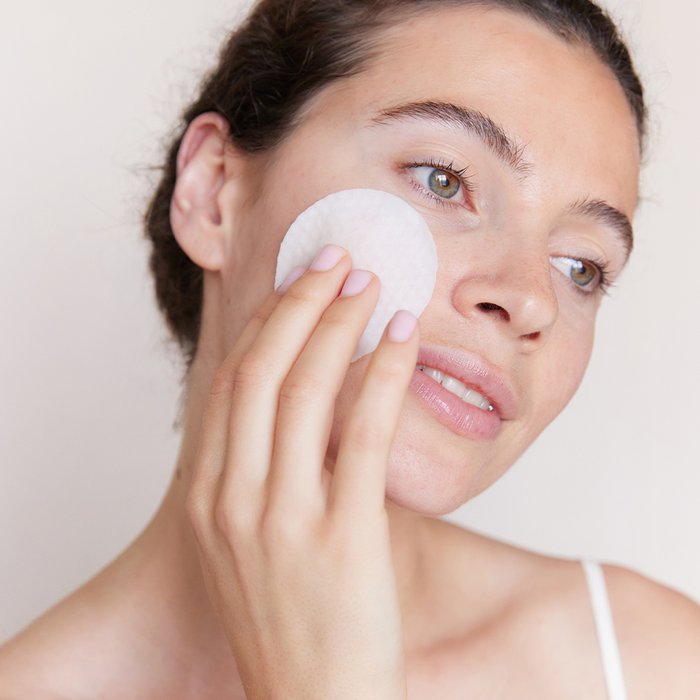 Une femme passant un pimple patch coréen sur son visage