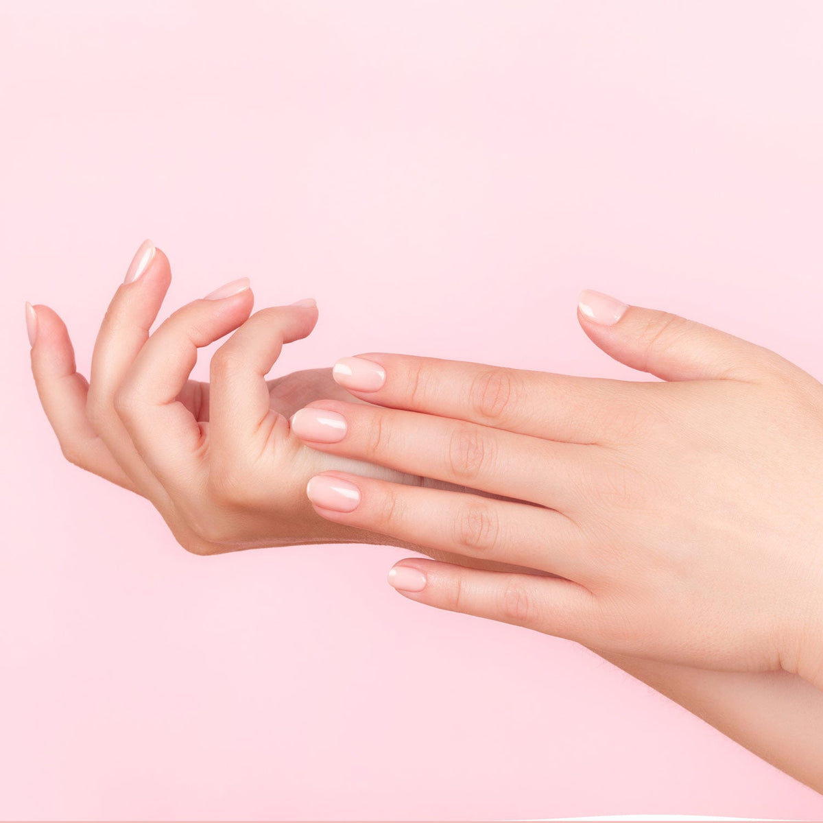 Mains de femmes qui se touchent avec de beaux ongles mis en avant